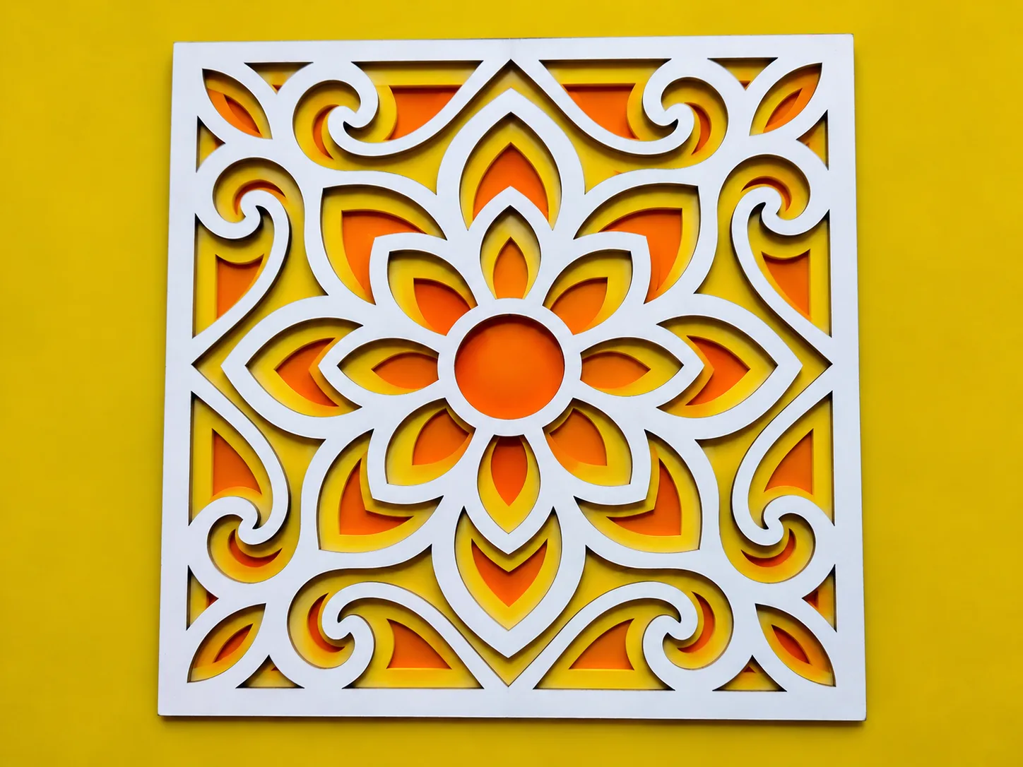 Three-layer floral wall panel with a white plywood front over orange and yellow acrylic sheets