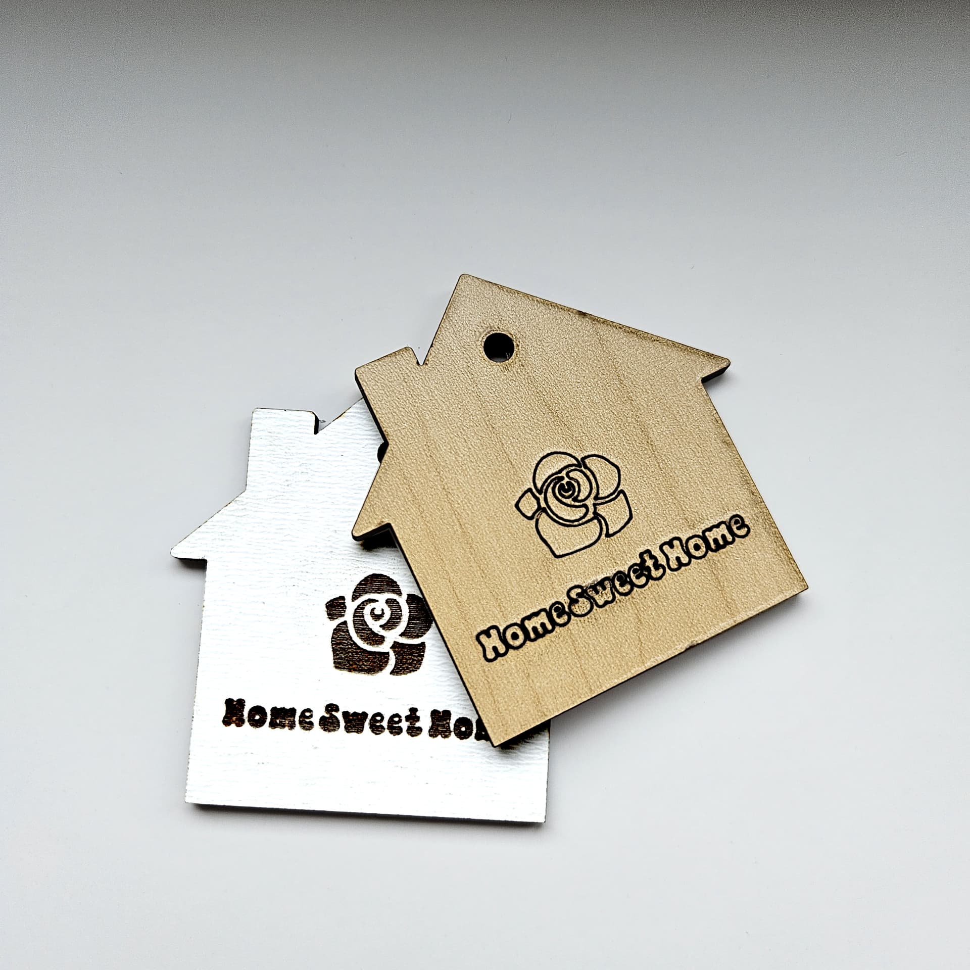 Laser-cut gift tag in the shape of a house, made from MDF core laser plywood.