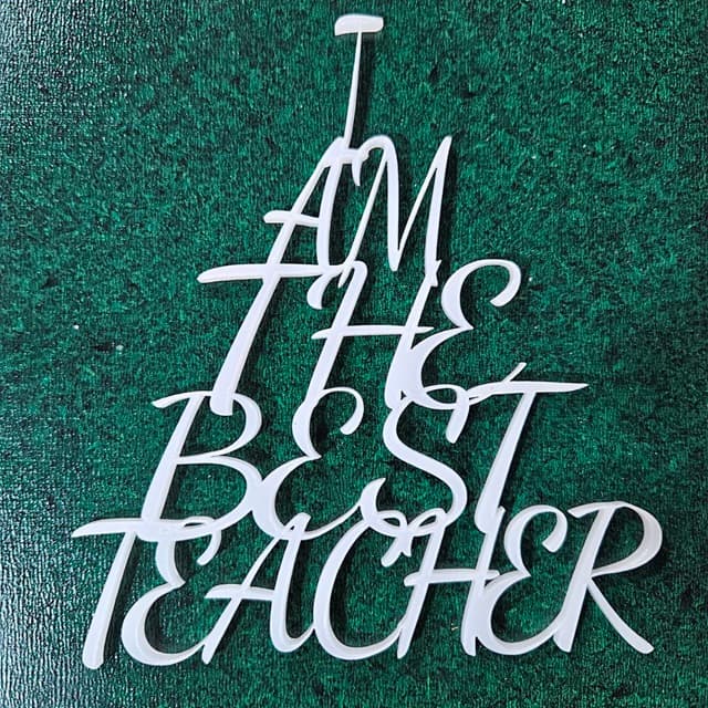 Laser-cut stacked text design saying 'I Am The Best Teacher' in triangle shape, crafted from semi-translucent acrylic and decorative plywood.