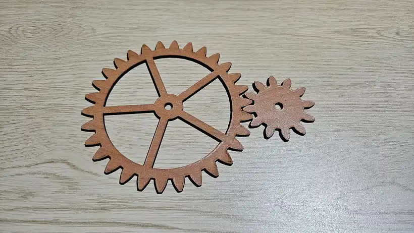 Laser cut spoked gear and matching pinion in cherry plywood with crisp involute teeth